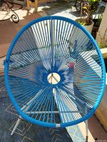 Photo shows circular blue nylon woven seat and metal frame of chair.