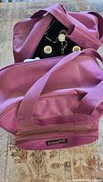 Pink canvas carrying bag with handles and front zip pocket