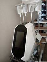Front and top view of white body contouring device with touchscreen and four attached applicator arms