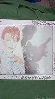 Front cover of David Bowie 1980 'Scary Monsters' album showing artwork with Bowie's portrait and shadowy figure.