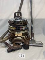 Front view of Model 700 Filter Queen vacuum cleaner with hose, attachments, and number plate