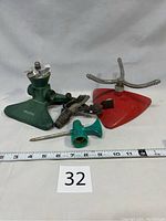 Four assorted sprinklers shown together from front angle with measuring tape and lot number visible