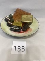 Full view of enamelware bowl containing the vintage items including Evans tin, rubber stamps, loupe, pulleys, and gold pouch