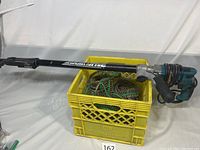 Full view of Quick Drive system mounted on drill handle with extension tube and crate of collated screws