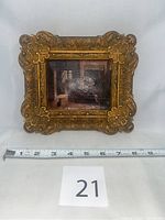 Full frontal view of the miniature oil painting in ornate gold frame next to measuring tape showing size about 8 inches wide.