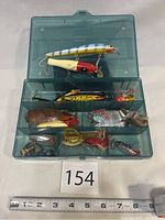 Full tackle box open showing all compartments filled with various fishing lures and weights