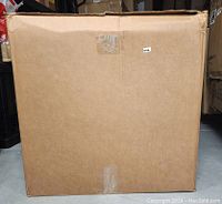 Photo of sealed, plain brown cardboard box containing the Cozy Cave Cat Box Furniture in Gray with Wooden Legs