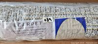 Photo of the rolled up rug packaging showing the ECARPETGALLERY brand label and Collection Symphony designation.
