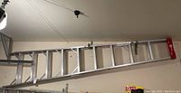 Full view of the 9 foot aluminum ladder hanging horizontally showing the length and step spacing.
