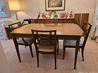 Frontal view of table and six chairs in carpeted room