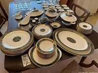 Full set overview with dinner plates, side plates, teacups, saucers, serving dishes and accessories laid out on table