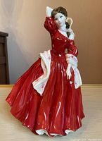 Front view of Royal Doulton Ellen figurine in red dress with white floral shawl and hat