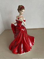Front view of Royal Doulton Pretty Ladies figurine dressed in a red gown with necklace and headband.