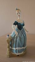 Front view of the Royal Doulton figurine Clarinda HN 2724 showing detailed facial features, dress and bird on pedestal.