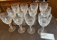 Twelve crystal red wine glasses arranged on tabletop