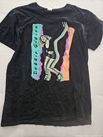 Front view of black Debbie Gibson tour t-shirt with colorful graphic and text on front.