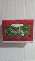 Box for Harley-Davidson Fat Boy Keepsake Ornament showing front packaging with red and green festive colors and product name.