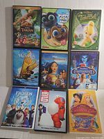 Top view of first 9 DVDs including Tarzan, Puppy Dog Pals, Tinker Bell, Moana, and others