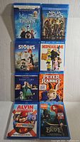 Top view of 9 Blu-ray children's movies vertically stacked showing front covers including Frozen, Ninja Turtles, Storks, Despicable Me 2, Peter Rabbit, Alvin and the Chipmunks, Brave.