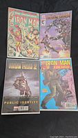 Image showing four Iron Man comic books including The Invincible Iron Man and Iron Man 2 titles with colorful covers.
