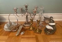 Full view of assorted candle holders and decorative items on wooden floor.