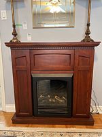 Full front view of the stained wood electric fireplace and mantle unit, showing shape, color, and style.
