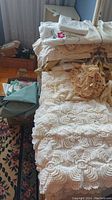 Wide view showing stacked assorted linens including crocheted doilies, sheets, towels, and pillow cases.