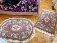 Photo showing both the oval and rectangular matching rugs placed on hardwood floor, featuring floral pattern and fringes.