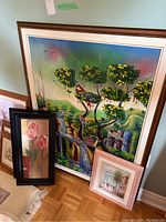 Four pieces of wall art grouped together: two large paintings leaning against the wall, two smaller framed prints placed in front. Shows condition and size relation.