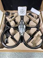 Drone and accessories packed in original molded cardboard inserts in box