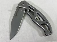 Open folding pocket knife showing stainless steel blade with GERBER logo and skeletonized handle.