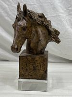 Front view of cast resin horse head bust sculpture on a glass base showing detailed horse features and textured mane.