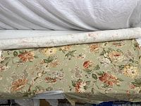 Roll of vintage floral upholstery fabric with muted orange, yellow, pink, and green flowers on beige background, 54 inches wide.