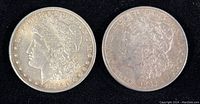 Obverse view of two Morgan silver dollars dated 1885-O and 1886 no mint mark.