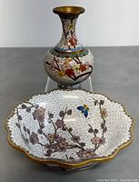 Front view of the two-piece Asian style cloisonné set: a scalloped bowl and a bud vase decorated with floral and cloud patterns.