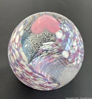 Top view showing the colorful internal patterns and pink heart shape inside the glass paperweight.