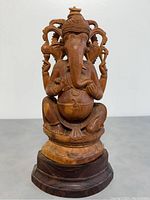 Front view of the intricately carved Indian Ganesh statue on a tiered dark wooden base.