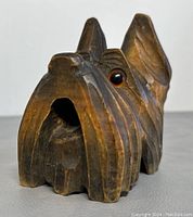 Front view of the carved wooden dog head bell showing carved details and eye.