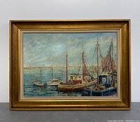 Framed oil painting showing several boats docked at harbor near shore, signed lower right by artist H. Davismes, with visible light wear on frame.
