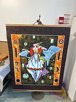 Full view of scroll painting hanging against a plain wall, showing entire artwork with borders and mounting.