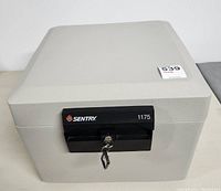 Top and front view of closed Sentry Safe Model 1175 with key in lock
