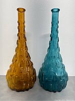 Front view of both vases showing textured pattern and color difference (amber and teal)