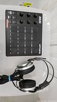 Top view of AKAI MPD218 MIDI pad controller and Sony headphones showing pads, knobs, and headphone design.