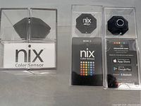 Three NIX Color Sensors including one Original Pro and two Mini 2 units in individual clear plastic packaging showing product and brand details.