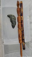 Three items displayed: soapstone seal carving, wooden laughing stick, and wooden flute with carved designs