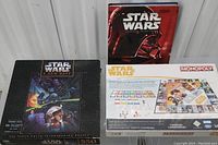 Photo showing Star Wars Monopoly box, Star Wars Trilogy book set hardcover, and Star Wars A New Hope 550-piece puzzle box.