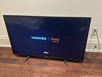 TV turned on showing Toshiba Fire TV logo screen indicating it is a smart TV and is functional.