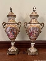 Front view of both urns side by side showing overall shape, lids, and handles