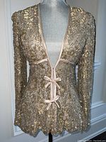 Front view of metallic sequin jacket on dress form