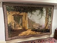 Large tapestry hung on wall showing full Amalfi coast scene with shade and architectural details.